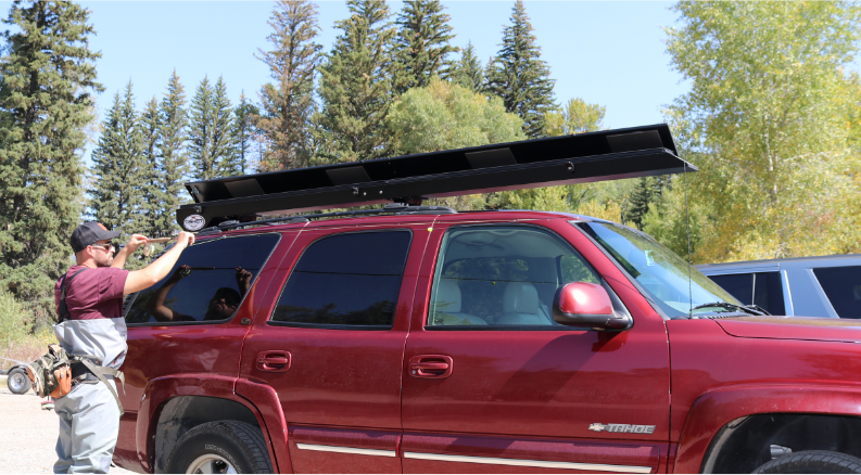 Black Asher Rod Locker installed on the top of a red Chevrolet Tahoe.